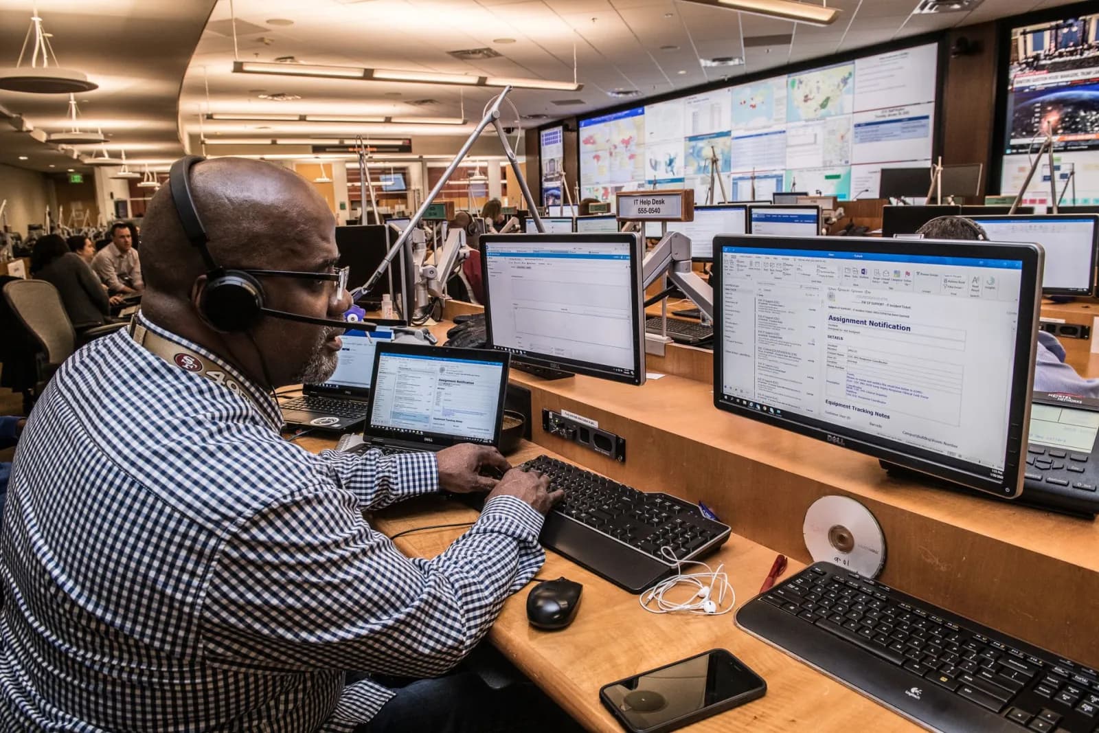 Tecnico al lavoro davanti a più monitor durante il monitoraggio continuo di dispositivi e sensori IoT