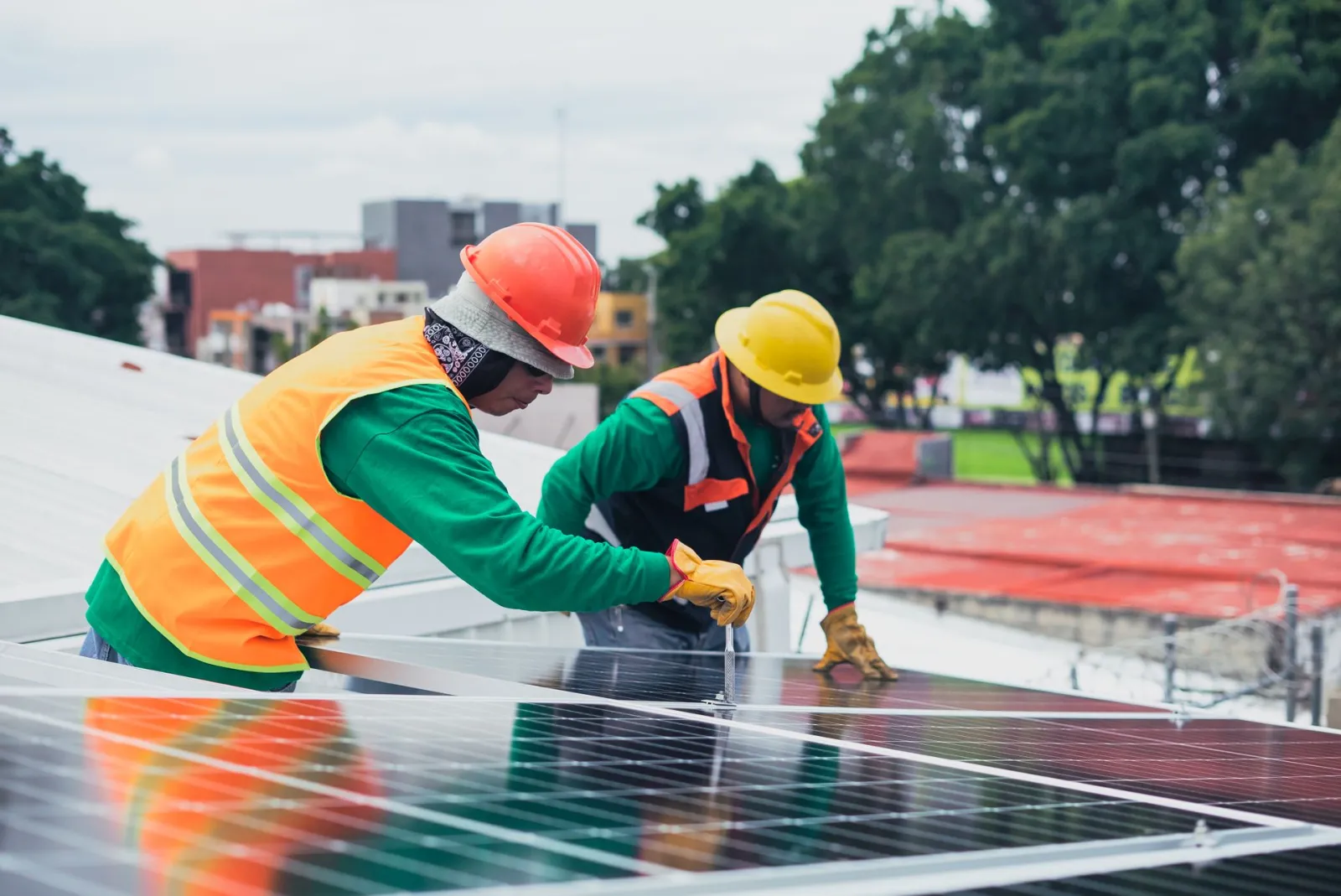 Tecnici al lavoro sull'installazione di pannelli fotovoltaici sul tetto di un capannone aziendale